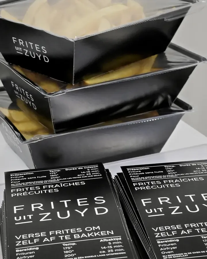 Verpakte verse frites en stapels bedrukte wikkels op de inpaktafel