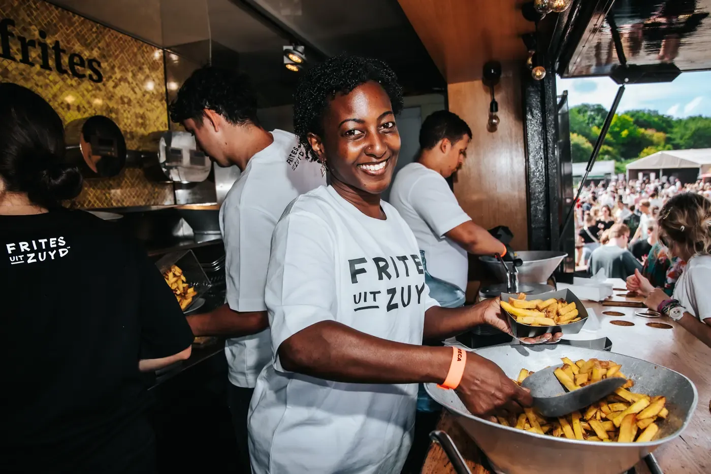 Medewerker schept verse frites in de foodtruck